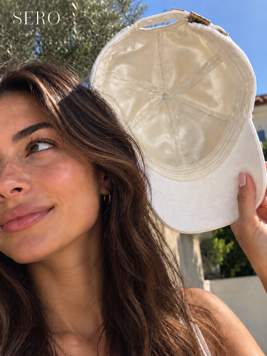 A person holding the Canvas Cap to show its ivory silk lining.