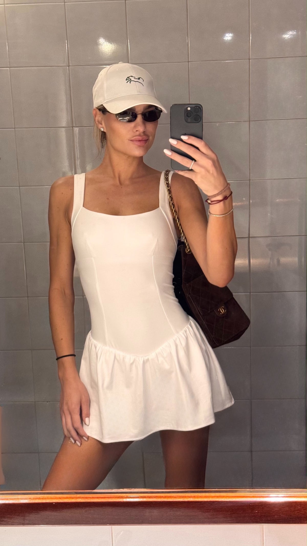 A person wearing the Canvas Cap, a white baseball cap, in a mirror selfie.